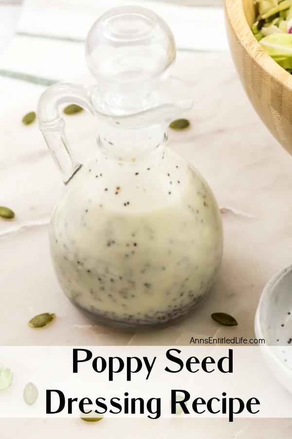 A cruet filled with poppy seed dressing, a partial view of a salad to the right side