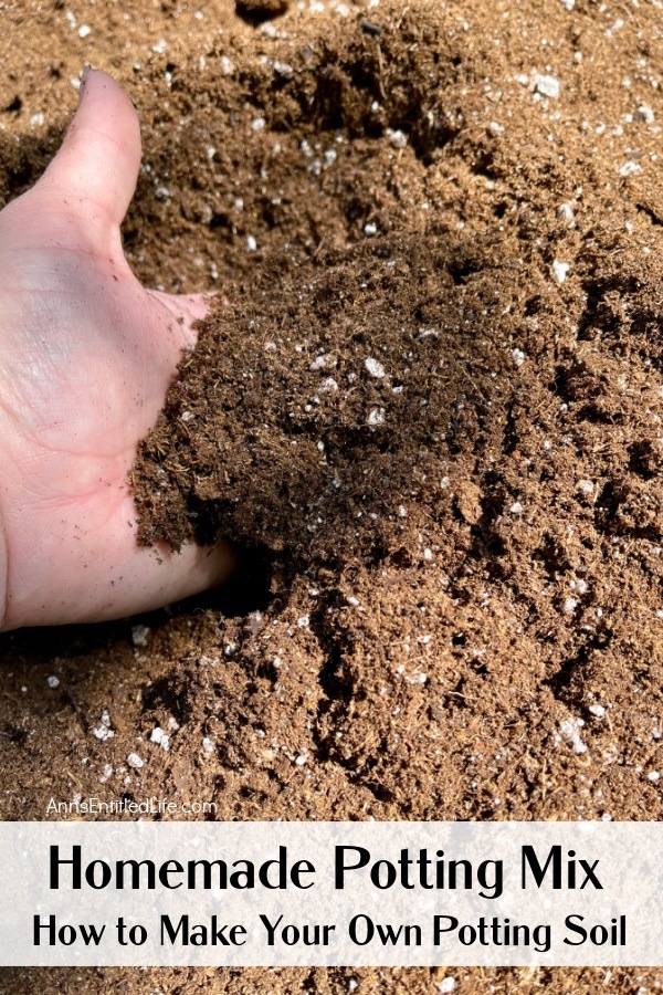 a hand scooping up some potting soil