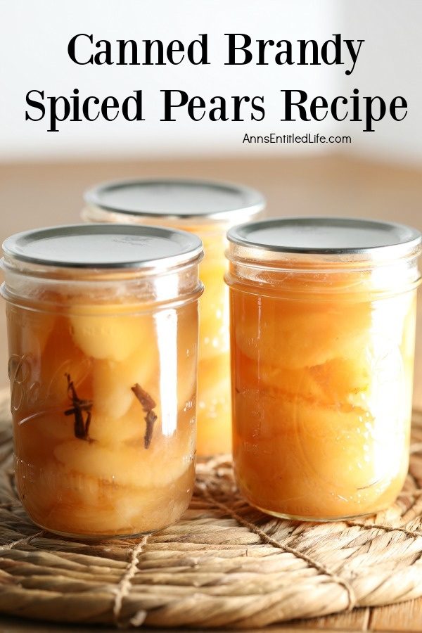 Three jars of canned brandy spiced pears sitting on a rattan placemat