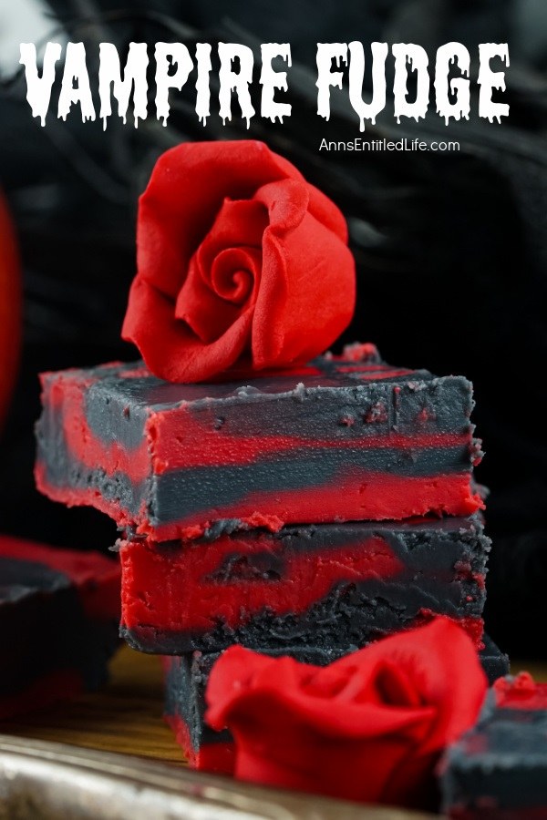 Three pieces of stacked red and black fudge set against a black background. There is a red rose on top