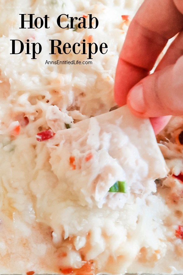 A close-up of a scoop of crab dip on a pita being lifted from the baking dish