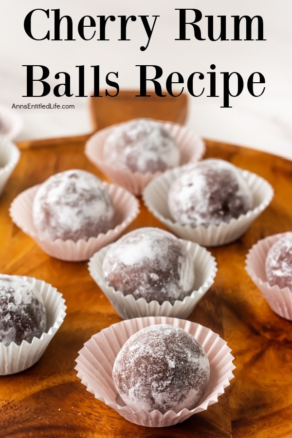 Side view of seven cherry rum balls in a white candy wrapper sitting on a wooden board.