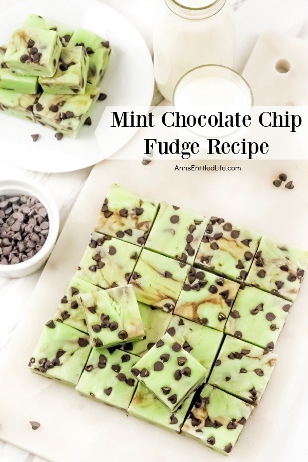 An overhead view of a slab of mint chocolate chip pieces on a whiteboard. The upper right has a glass of milk, to the upper left is a pile of pieces of mint chocolate chip fudge on a white plate, below that is a white bowl of mini chocolate chips.