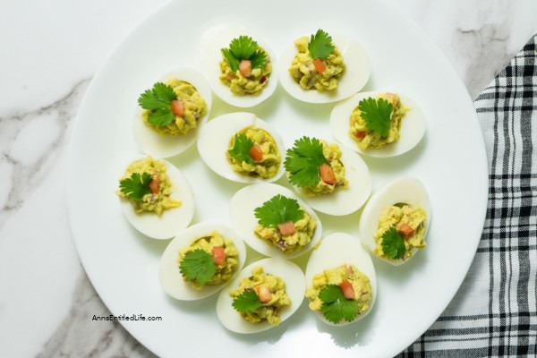 Avocado Deviled Eggs Recipe. These guacamole-inspired deviled eggs that are made with avocado, lime, tomato, and onion are simply delicious! Easy-to-make these avocado deviled eggs are a perfect party appetizer, great for picnics, tailgating, or for a snack for those on low-carb diets.