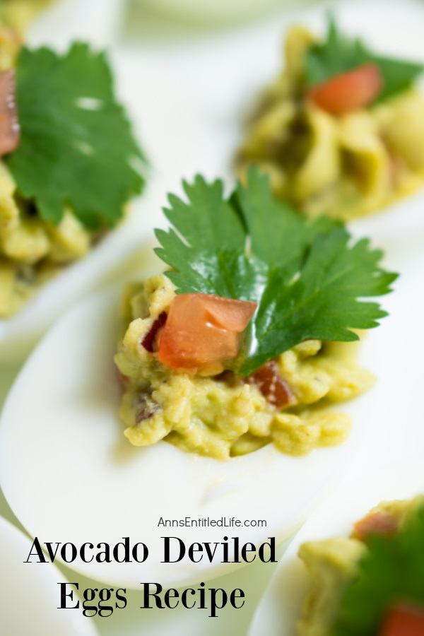 Overhead close up of a avocado deviled egg on a white plate, there are several others in the background