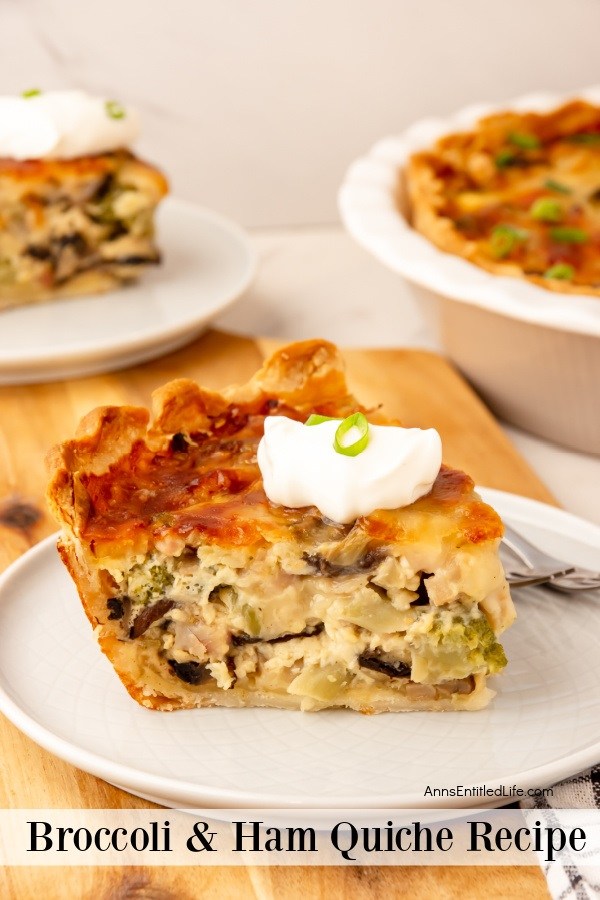 a piece broccoli and ham quiche on a white plate, the rest of the quiche is in a white pie pan with a piece removed in the upper left