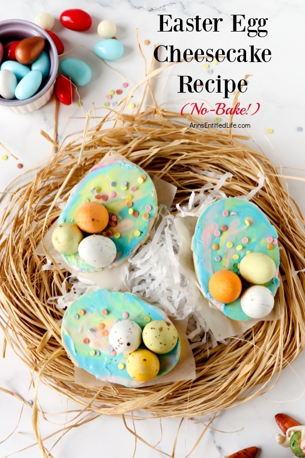 Overhead shot of three Easter cheesecake set on a nest of straw. There are some easter candies in the upper right in a white bowl.