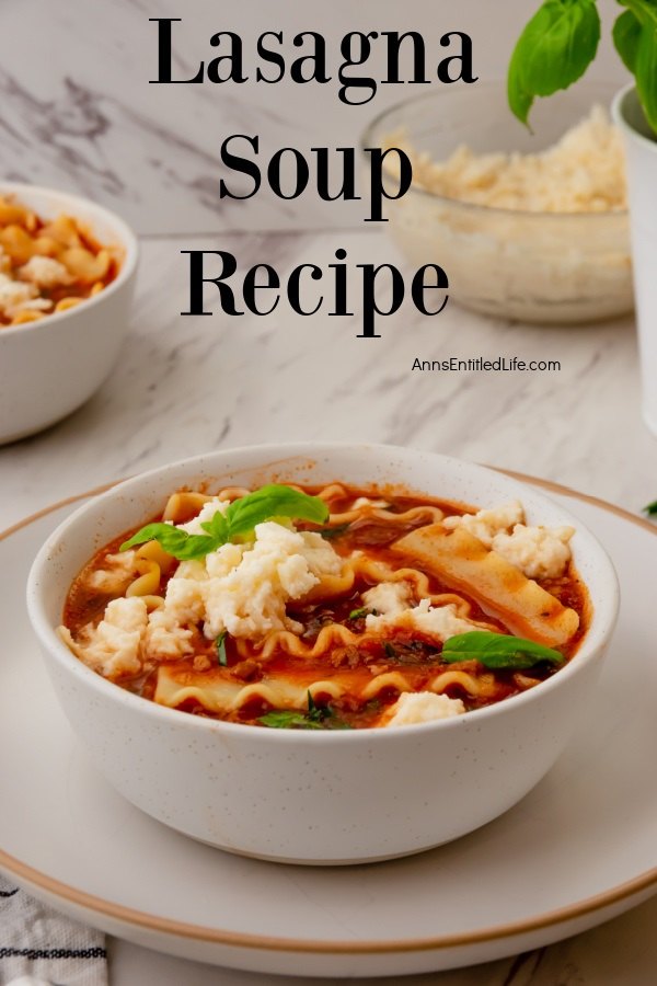 Profile view of lasagna soup in a white bowl. There is a second bowl in the upper left. A bowl of cheese sits in the upper right. These are set on a marble top.