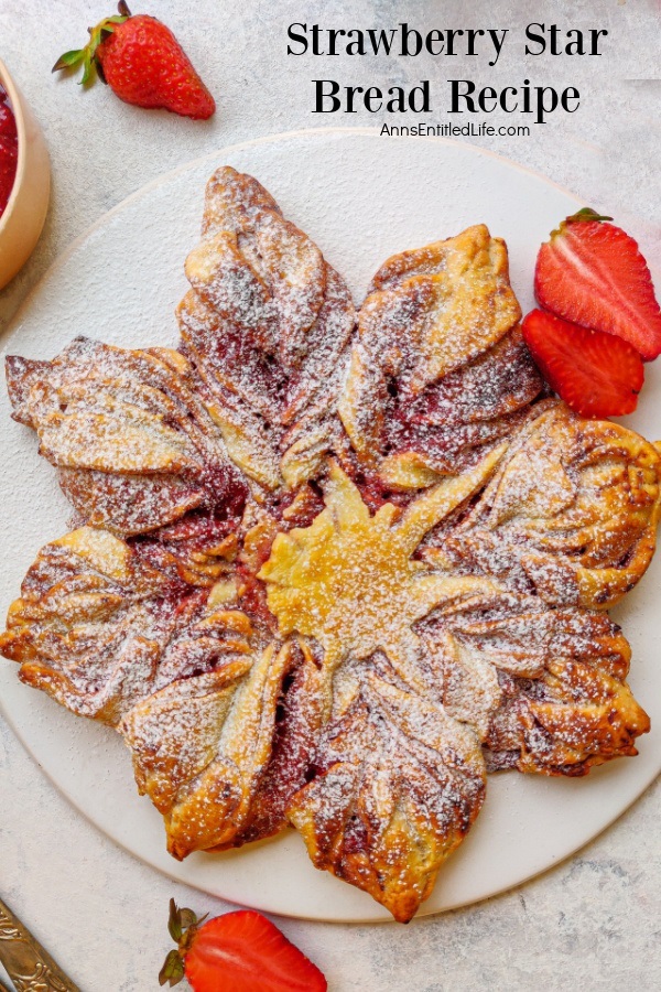Overhead view of a strawberry bread in the shape of a star on a white plate. Fresh, sliced strawberries garnish the plate.