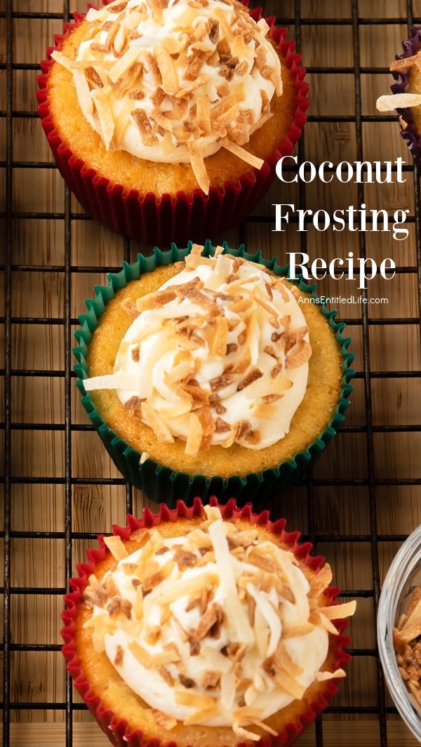 3 cupcakes on a baking rack frosted with coconut frosting and sprinkled with toasted shredded coconut