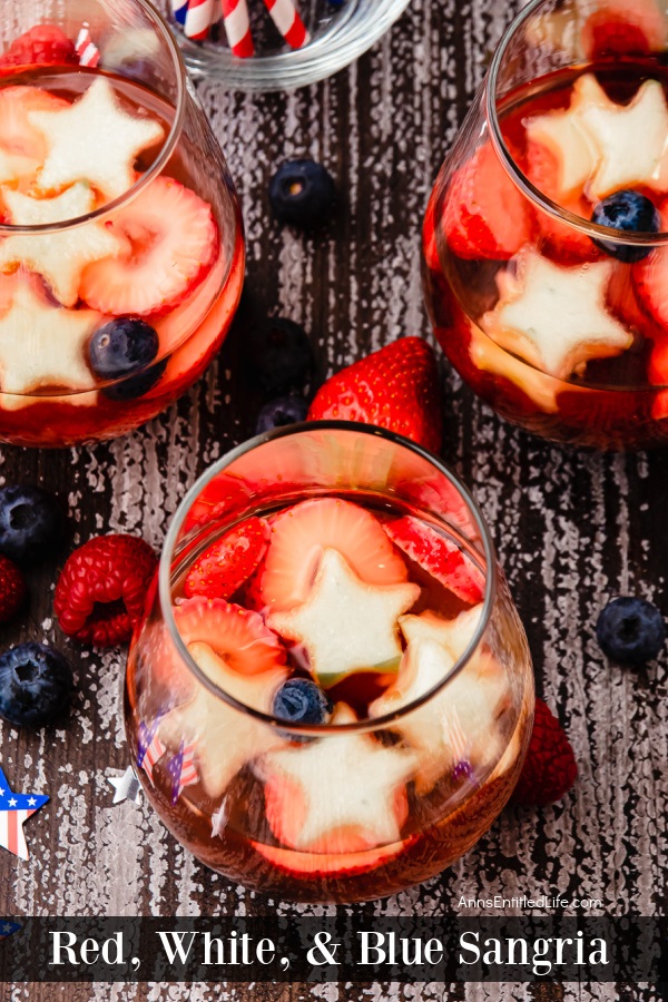 Overhead view of three glasses of red, white, and blue sangria. The glasses are clear and set on a black and white background.