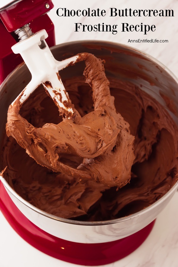 Upclose image of beaten chocolate buttercream frosting on a stand mixer paddle lifted from the bowl beneath