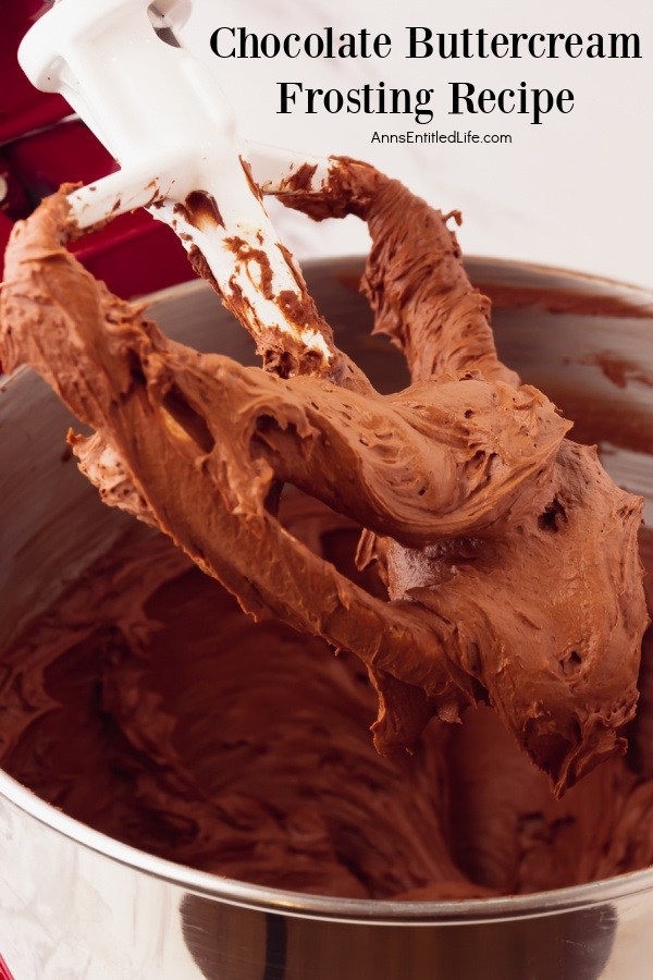 Image of beaten chocolate buttercream frosting on a stand mixer paddle lifted from the bowl beneath