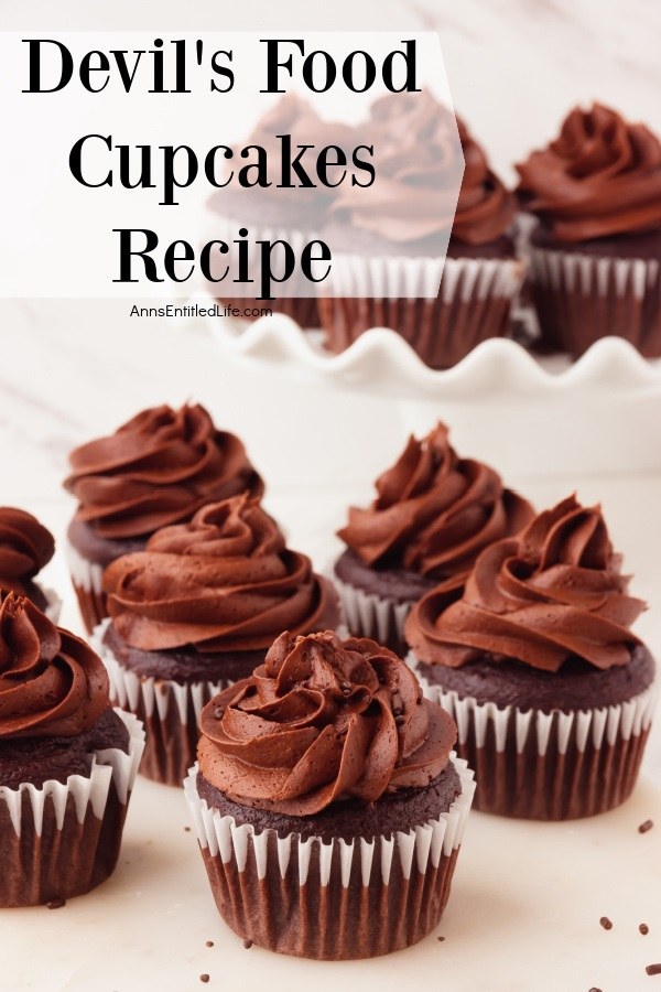 Six devil's food chocolate cupcakes on a white counter, there are another six on a white plate in the upper right