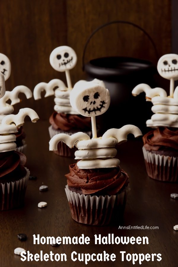 four skeleton Halloween cupcakes against a dark background