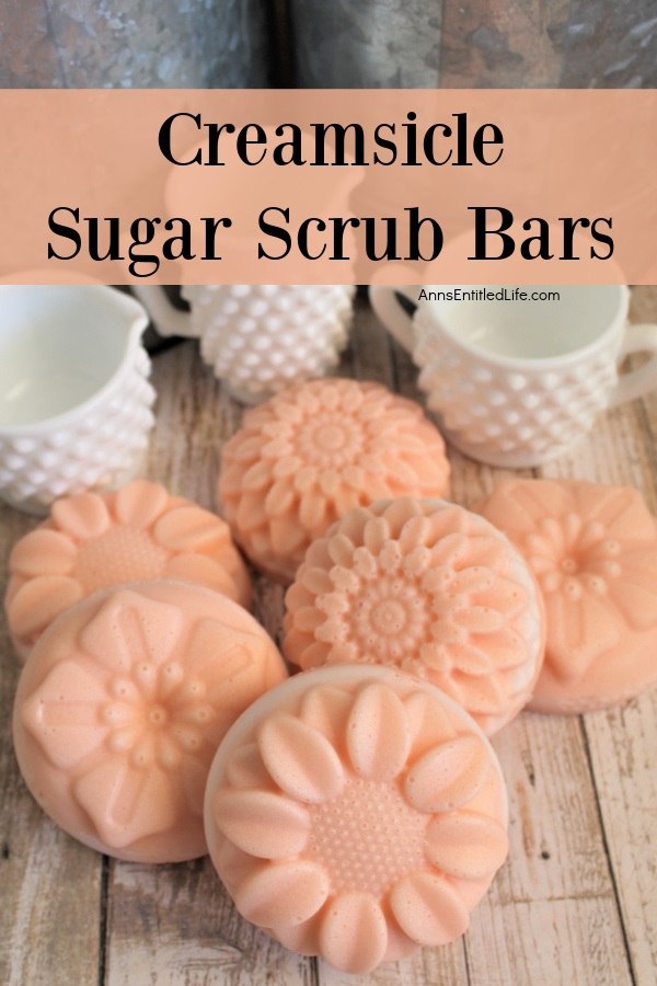 6 creamsicle sugar scrub bars on a wooden board. Three small pieces of milk glass are in the background