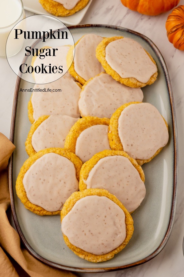 A white platter filled with pumpkin sugar cookies