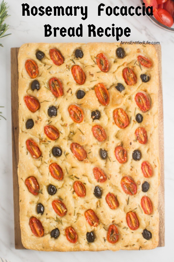 A cutting board with a full sheet of rosemary foccaia bread