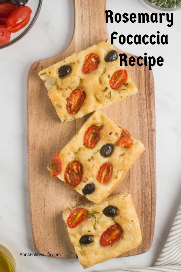 A cutting board with three pieces of cut rosemary foccaia bread, small bowls of ingredients are partically shown in the corners