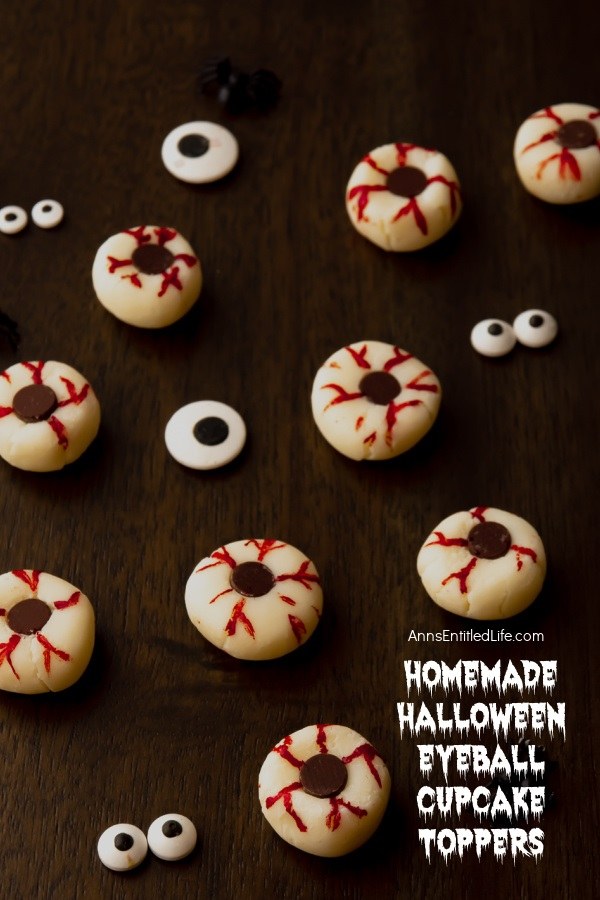 An array of Halloween eyeball cupcake toppers are set on a dark background