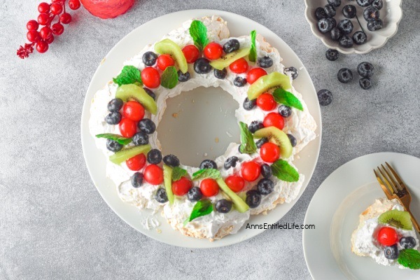 Christmas Pavlova Recipe. Pavlova is a meringue-based dessert with a crispy top and a soft, marshmallow-like center. This Christmas pavlova is topped with a generous amount of sweet vanilla whipped cream and sliced fruits and berries, which makes this classic dessert absolutely delectable. This wreath-shaped pavlova is perfect for Christmas day and is a real crowd-pleaser.