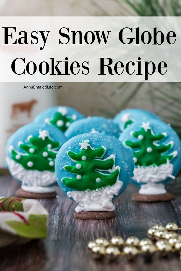 Six Christmas tree snow globe cookies standing on a wooden surface
