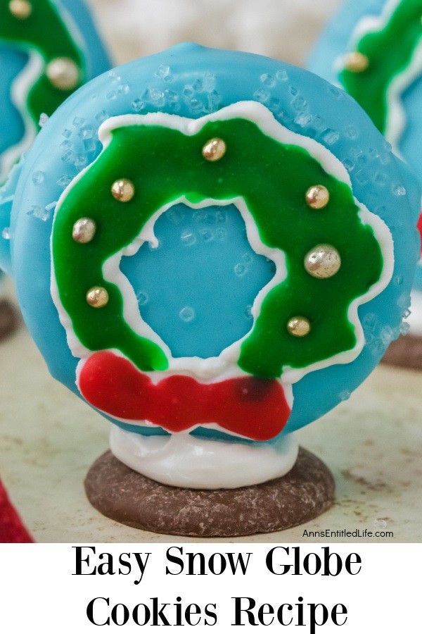 A snow globe wreath cookie standing on a white surface