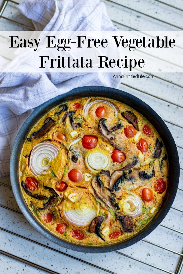 a skillet baked with egg-free vegetable frittata sitting on a grey counter, a blue and white checked napkin on the left