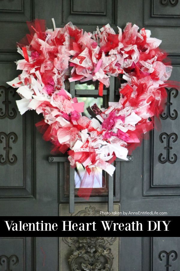 a heart shaped red, white, and pink Valentine's day wreath hanging on a front door