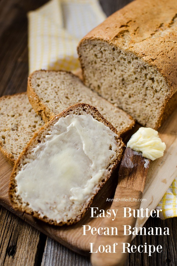 Close-up of a sliced butter pecan banana loaf on a cutting board, the most forward piece is buttered