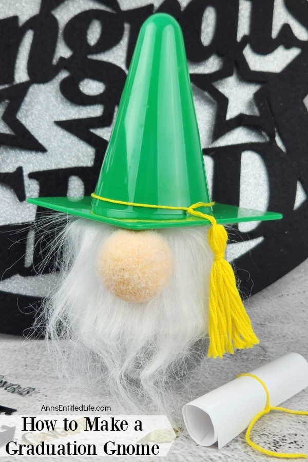 a homemade garden gnome on a marble top, a small diploma sits to the right along with graduation confetti, a congratulation sign is in the background