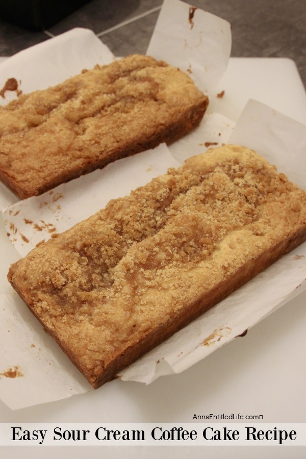Two sour cream coffee cake loaves on white parchment paper