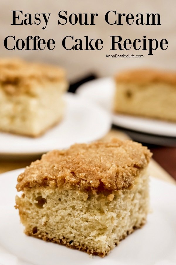 A piece of sour cream coffee cake on a white plate. The pan filled with the rest of the coffee cake is in the upper right, another piece on a white plate is in the upper left.