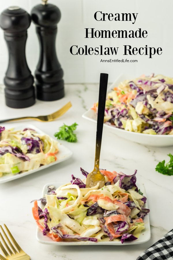 A square white plate, a fork embedded in the middle is filled with coleslaw and sits front and center, a heaping bowl of coleslaw is in the upper right, a second plate of coleslaw sits to the left, and wooden salt and pepper shakers are in the upper left