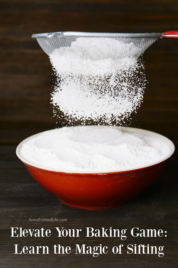 A red bowl filled with sifted flour, a fine mesh strainer is sifting above it.