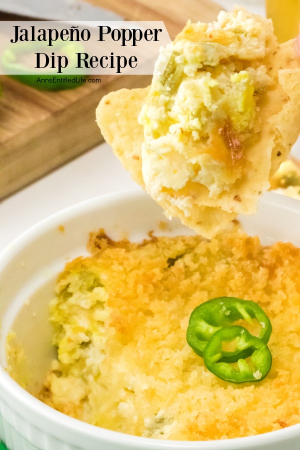 A chip of jalapeno popper dip is being removed from the ramekin filled with jalapeno popper dip below