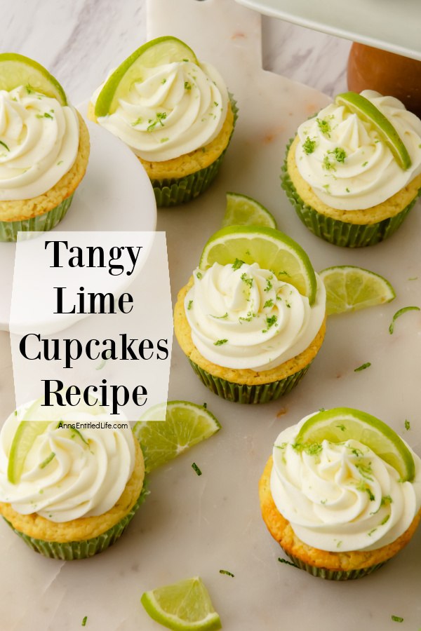 Overhead view of six frosted and decorated lime cupcakes in green wrappers on a white surface. There are some cut limes strewn about the surface, too.
