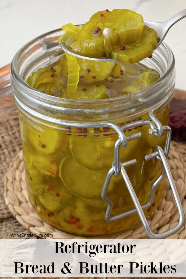 Homemade bread and butter pickles being lifted from a jar by a spoon