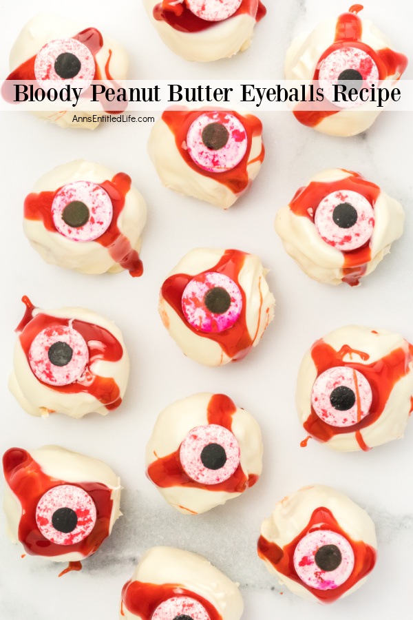 a white surface with a dozen no-bake peanut butter eyeballs laid out