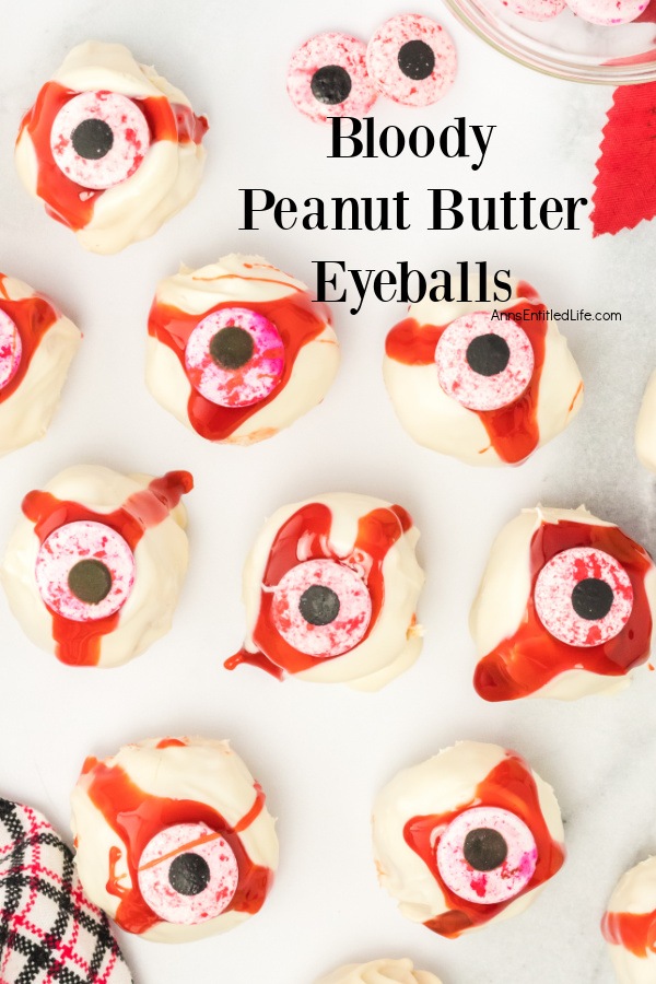 overhead view of a white surface with a dozen no-bake peanut butter eyeballs laid out