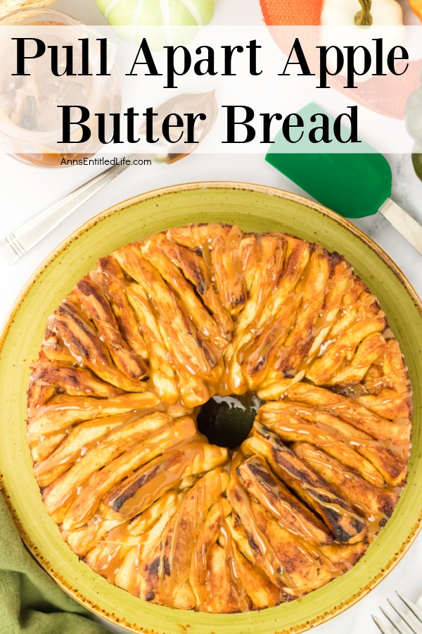 overhead view of a pull-apart apple butter bread on a green plate. There is a rubber spatula to the upper right, a spoon, and apple butter jar in the upper left