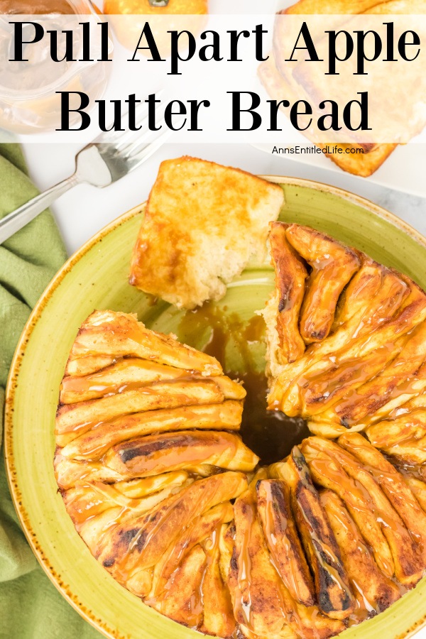 overhead view of a pull-apart apple butter bread on a green plate with a few peices missing. There is a rubber spatula to the upper right, a fork and apple butter jar in the upper left