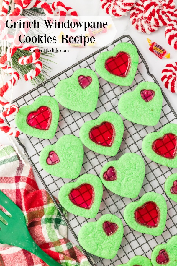 Green windowpane cookies on a wire rack surrounded by red and white holiday decorations