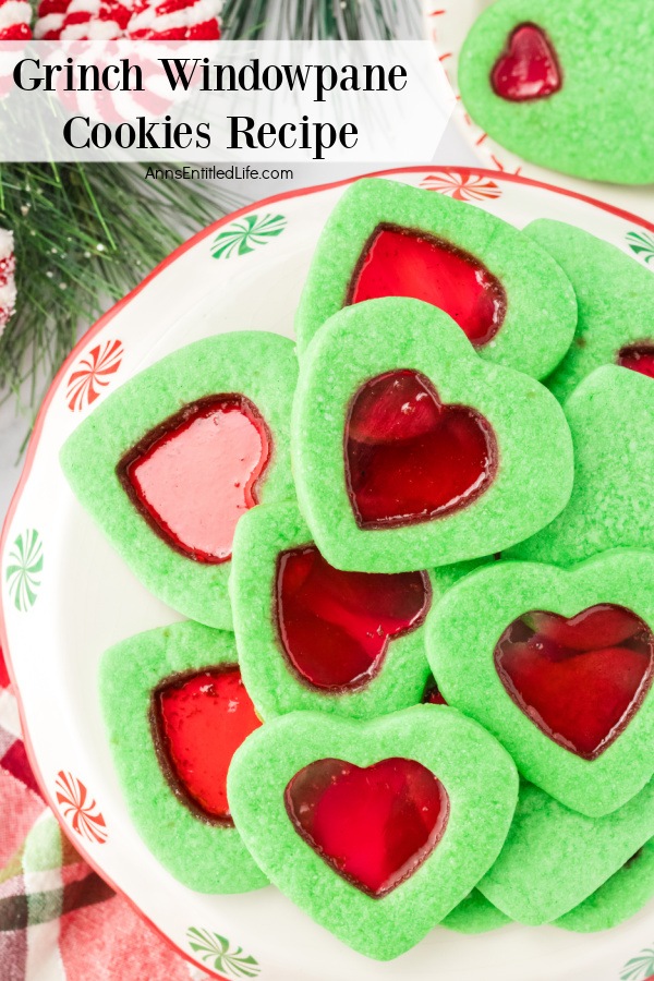 A holiday plate filled with green windowpane cookies on a white surface