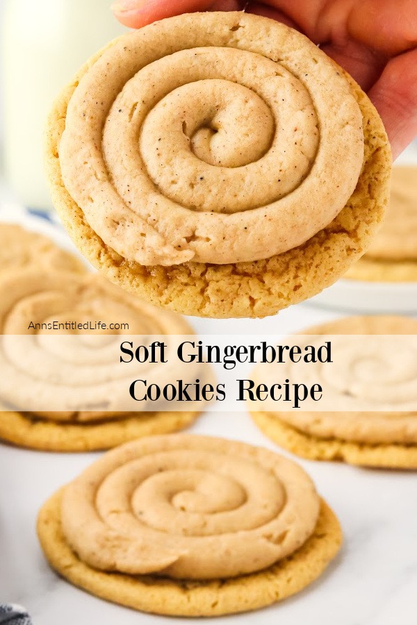 A female hand is holding a frosted soft gingerbread cookie, there are several cookies below