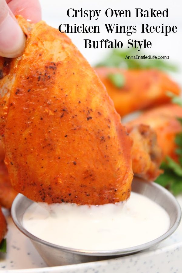 a flat baked chicken wing being dunked in a small container of blue cheese