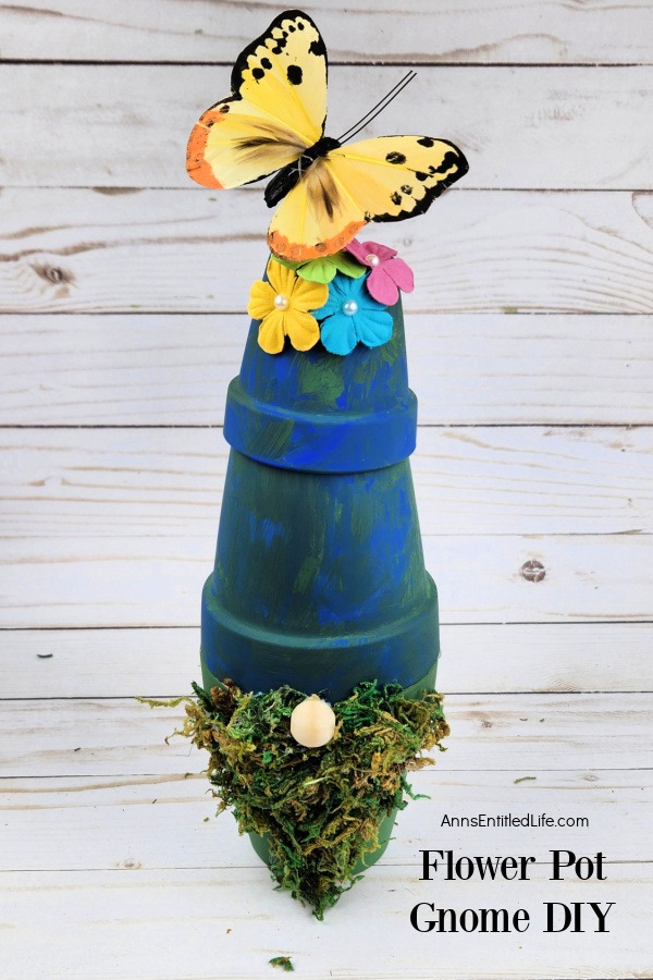 Homemade flower pot garden gnome against a grey board