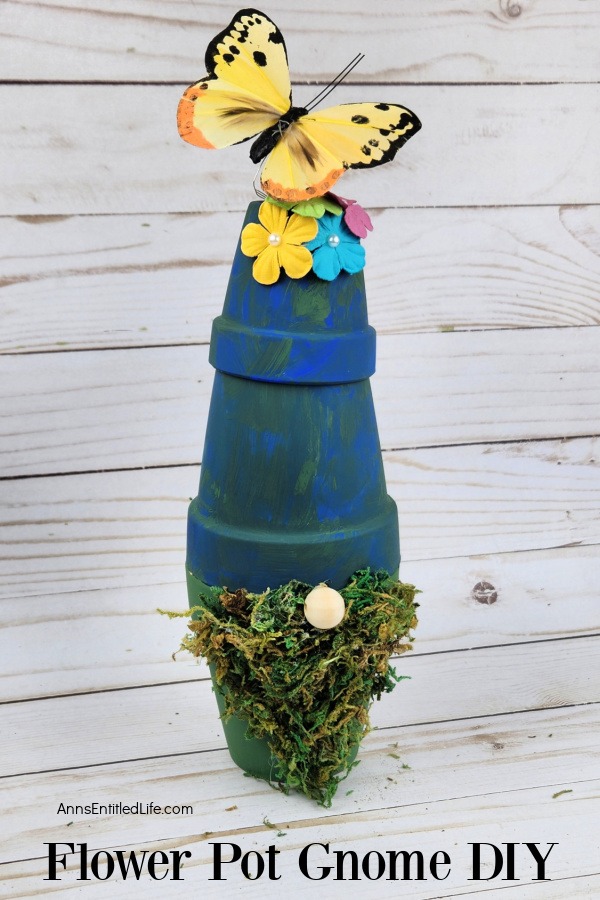 Homemade flower pot garden gnome against a grey board