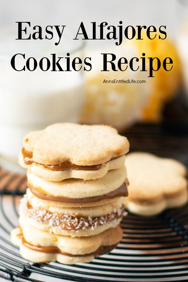 A stack of four alfajores cookies on a wire rack, one cookie in the upper right