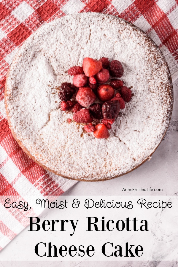 A whole berry ricotta cake set on a red and white checked cloth